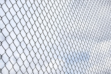 Fence pattern with clouds in the background