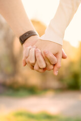 a guy and a girl are standing next to each other, holding hand by hand, vertical image.