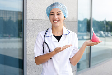 Medicine, profession and people concept - A smiling European woman nurse in a white coat with a...