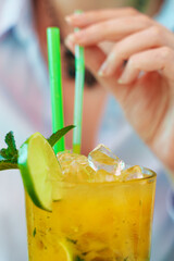 Woman holds delicious handmade lemonade with lime.