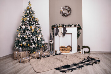 Cozy flat apartment room with green Christmas Tree gifts presents on carpet fireplace socks garlands, candles decorated interior New Year beautiful living room in the evening, lights glowing
