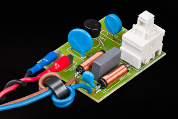 Electronic components of electric motor supply module on black background. Ferrite beads and...