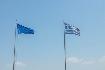 Close up view of Greece and Europe flags on blue sky background. Greece. 
