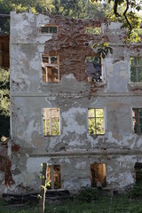Stary rozwalający się dom z cegły w promieniach słońca.  - obrazy, fototapety, plakaty