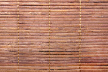 Texture backdrop photo of red colored bamboo mat sheet, front view.