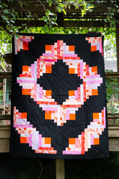 bold patterned quilt hanging outside