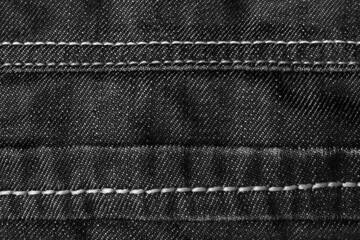 Texture backdrop photo of denim jeans cloth with seams and folds.