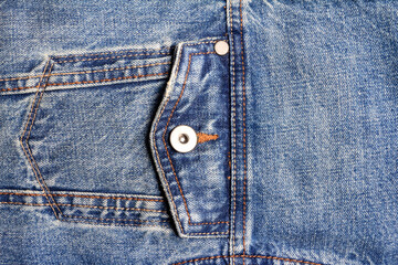 Texture backdrop photo of blue colored denim cloth with pocket and seams.