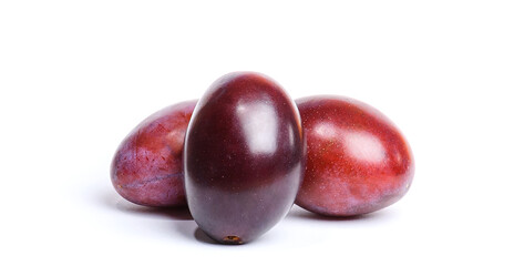three plums on a white background