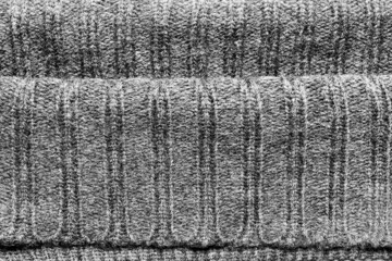 Texture backdrop photo of grey colored woold knitted fabric cloth folds.
