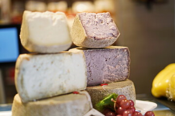 Pecorino, handmade semi-hard Italian cheese for sale in a cheese shop. Selective focus