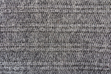 Texture backdrop photo of grey colored woold knitted fabric cloth.