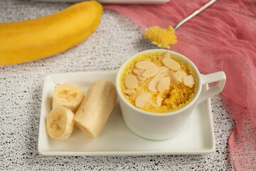 banana muffin in a mug on a plate. Fresh bananas next to homemade muffins. homemade magician cake is cooked in the microwave. Banana dessert, baked goods. High quality photo