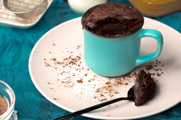 mugcake is microwaved. Homemade cupcake in a mug is on a plate. Chocolate brownie mug cake. Easy cooking concept, microwave baking. muffin chocolate. High quality photo