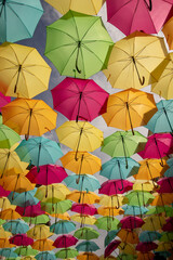 Fototapeta na wymiar The sky of colored umbrellas. Street with umbrellas. Umbrella sky project in Agueda, Aveiro district, Portugal. Agueda. Colorful street decoration umbrella 