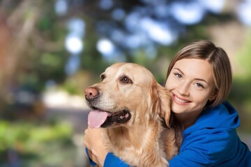 Portrait of beautiful girl petting and hugging dog outdoors.