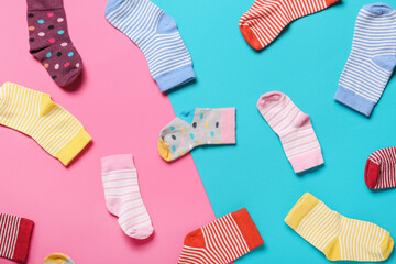 Stylish baby socks on color background