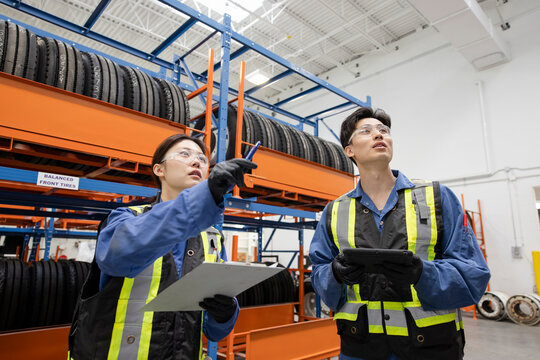 Workers looking at tires in maintenance facility warehouse