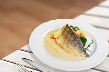 Traditional food tasty fish with vegetables on a plate