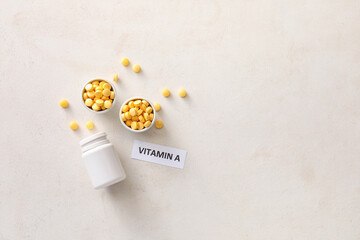Composition with text VITAMIN A and pills on white background