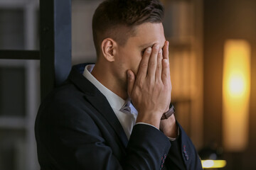 Depressed young businessman in office late in evening