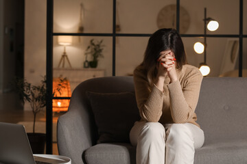 Fototapeta premium Religious young woman praying to God at home in evening