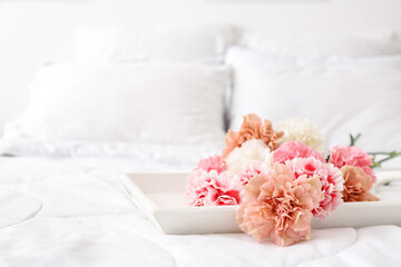 Bouquet of beautiful carnations on bed