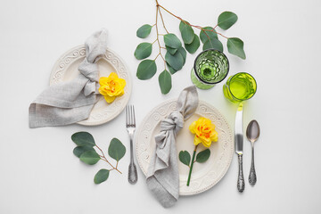 Beautiful table setting with narcissus flowers on white background
