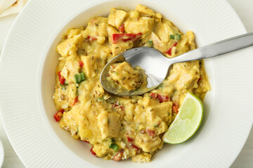 Plate of tasty chicken curry on table, closeup