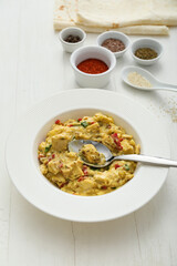 Plate of tasty chicken curry on light wooden background