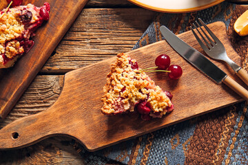 Board with piece of tasty cherry pie on wooden background