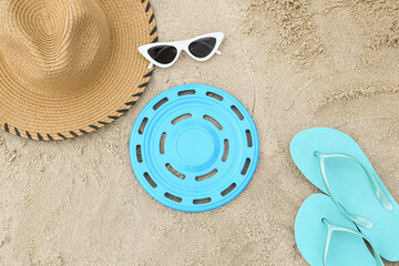 Composition with frisbee disk and beach accessories on sand