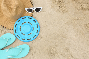 Composition with frisbee disk and beach accessories on sand