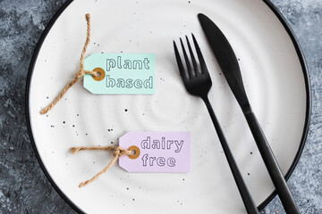 plant-based and dairy-free product tag on top of dining plate with fork and knife, healthy nutrition and ethical choices