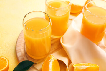 Glasses of tasty orange juice on color background, closeup