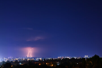 Naklejka premium Dark sky with lightning over night city