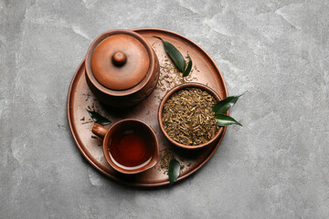Obraz na płótnie Canvas Tray with dry hojicha green tea and hot beverage on grey background