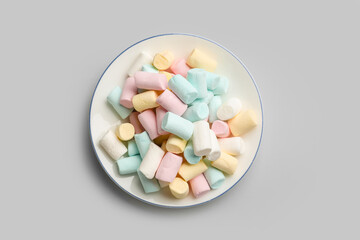 Plate with sweet marshmallows on grey background