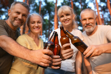 Mature people drinking beer at barbecue party outdoors