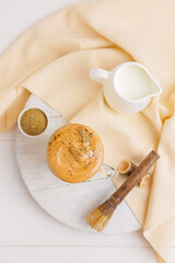 Composition tasty dalgona hojicha latte on light wooden background