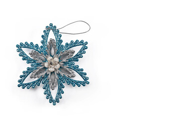 Silver Christmas bauble with blue for Christmas tree in the shape of a good night flower on white background with space for text, minimal concept