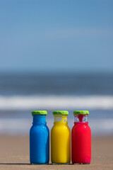 夏の海のビーチの砂浜にあるカラフルなガラス瓶の風景