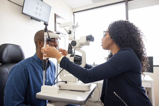 Optometrist Performing Eye Exam On Patient In Optometry Exam Room