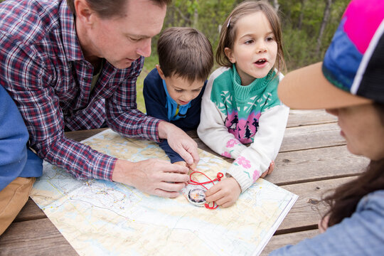 Family looking at map with compass