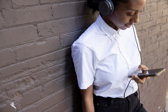 Young woman listening to music with headphones and smart phone