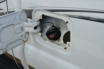 Fototapeta premium Vehicle fuel door open with gas cap in place.