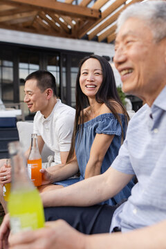Happy multigenerational family drinking soda on patio