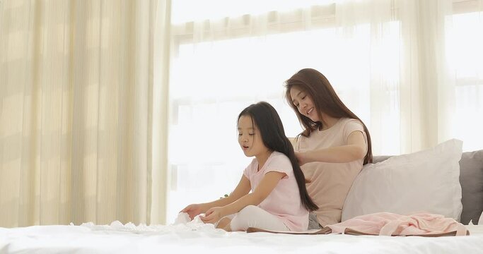 Happy mother combing her daughter's hair in bedroom,4K