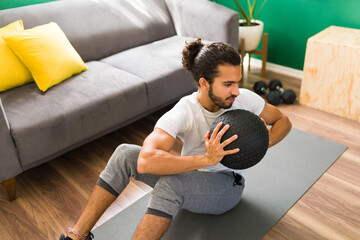 Attractive man working out with a slam ball