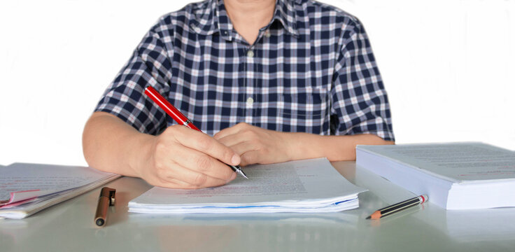 Isolated Hand Holding Red Pen Over Blurred Paperwork